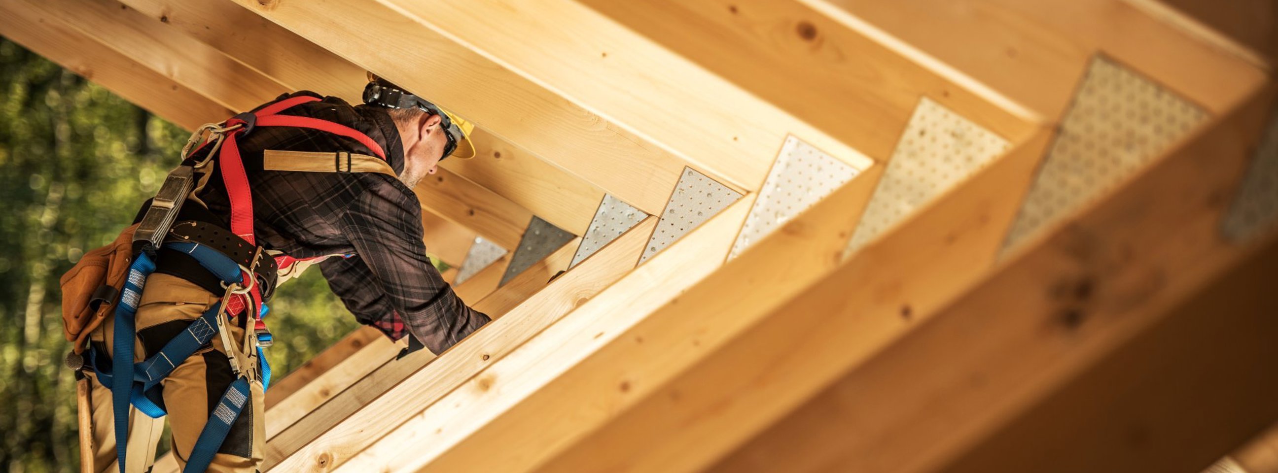 En håndværker er ved at montere nye spær på et hus