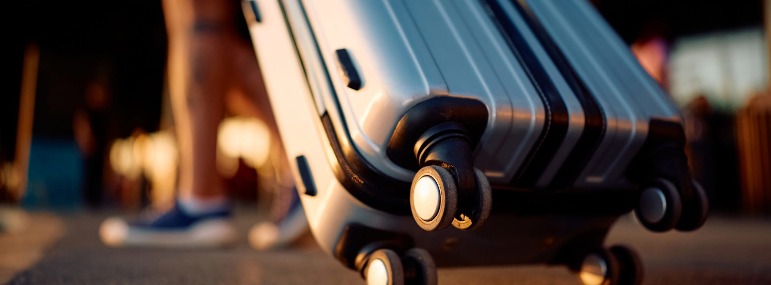 Close-up af rullekuffert, der bliver trukket foran lufthavn