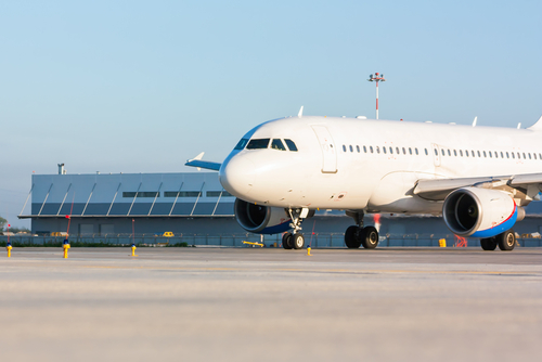 Fly der er på vej ind, ud og holder stille i lufthavn.