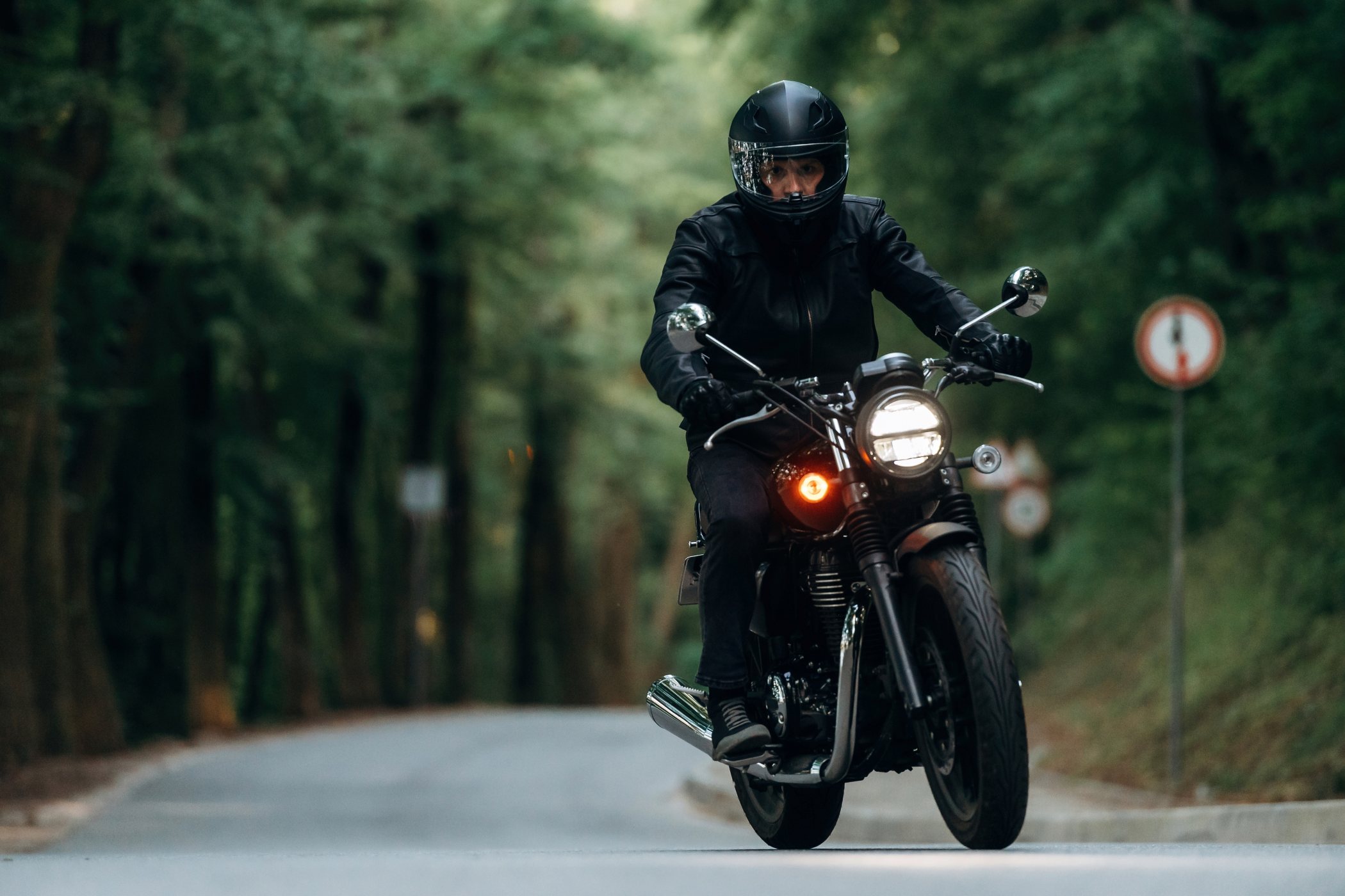 En mand med styrthjelm kører på sin motorcykel