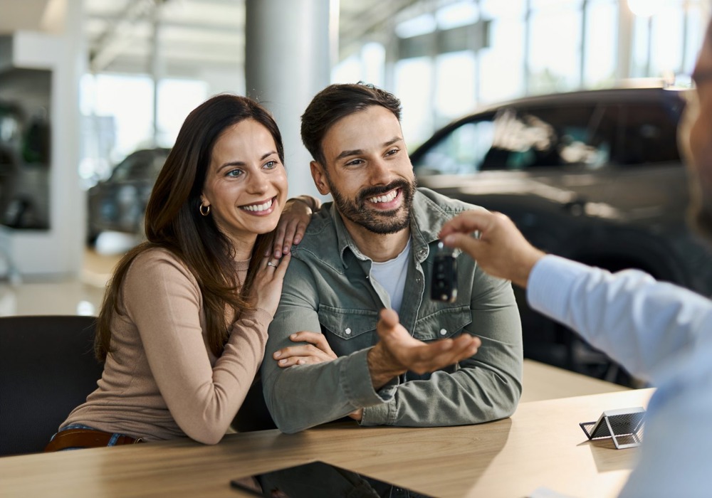 Par modtager bilnøgler ved køb af bil – illustration til gode råd om forsikring ved bilhandel