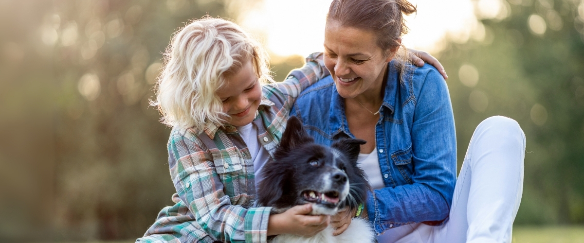 Mor og søn sidder udenfor sammen med deres hund